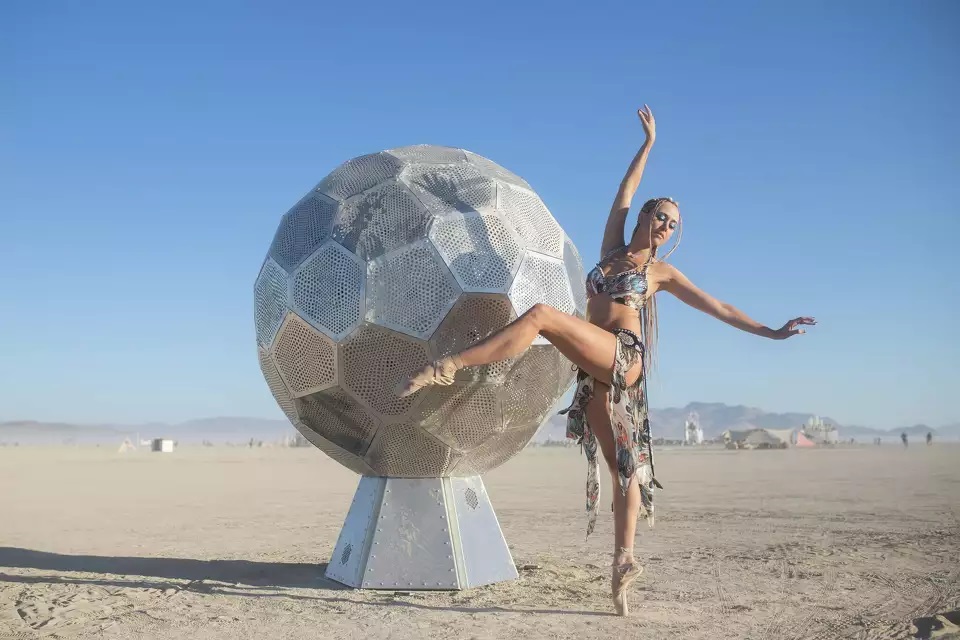 Marlowe Bassett của Metamorphosis Ballet khiêu vũ bên cạnh tác phẩm điêu khắc mang tên "Orbit" của Hayden Harrison tại Burning Man 2022. Ảnh: Jane Hu